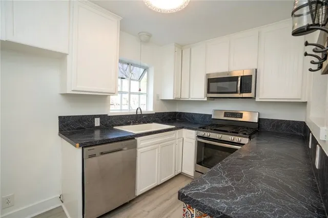 a kitchen with stainless steel appliances a stove a sink a microwave and cabinets