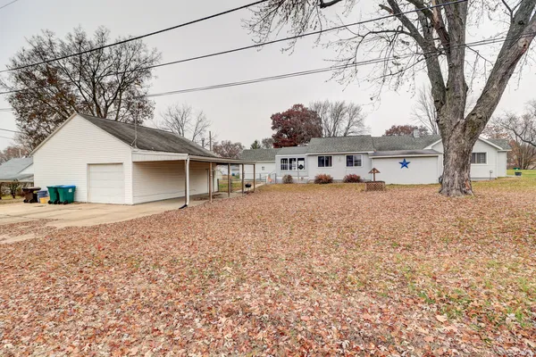 a view of a house with a large tree and a yard