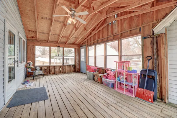 a living room with furniture a wooden floor and large windows