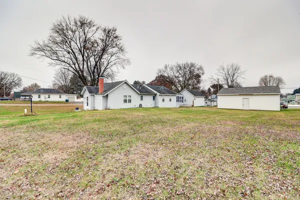 a front view of a house with a yard and lake view