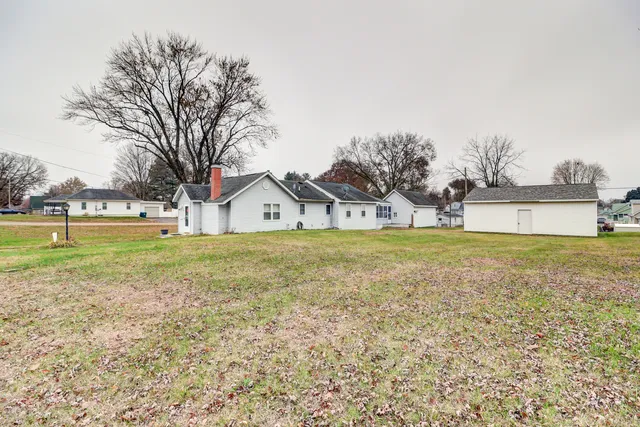 a front view of a house with a yard and lake view