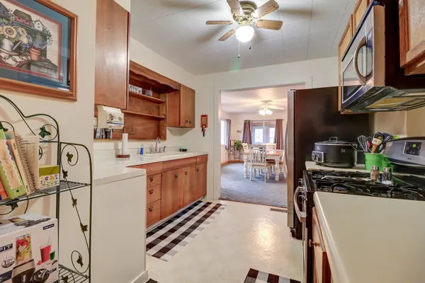 a kitchen with stainless steel appliances kitchen island granite countertop a refrigerator stove top oven and sink