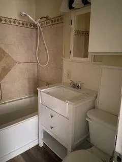 a bathroom with a granite countertop sink a toilet and shower