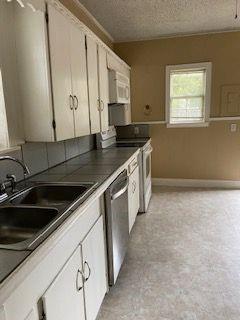 3366 South 7th Street Abilene, TX 79605 - Photo 5 of 16 a kitchen with stainless steel appliances a sink a stove and a refrigerator