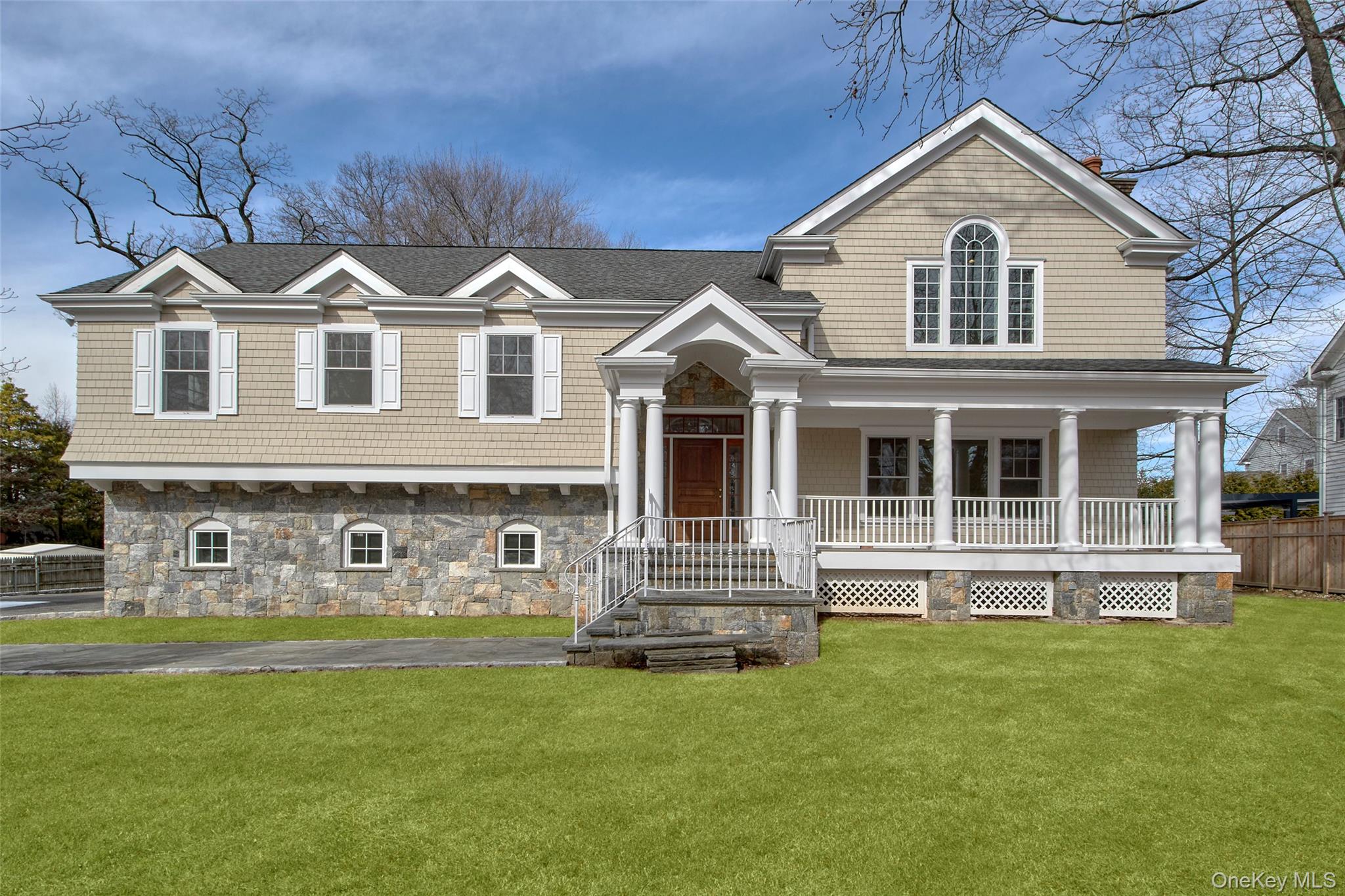 Welcome home to 8 Walden Lane with beautiful stone siding, architectural columns and a spacious front porch