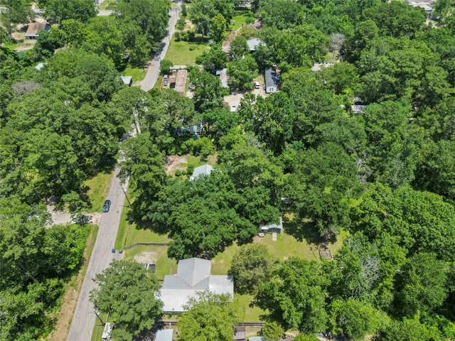 an aerial view of residential house with outdoor space and trees all around