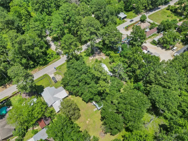 an aerial view of residential house with outdoor space and trees all around