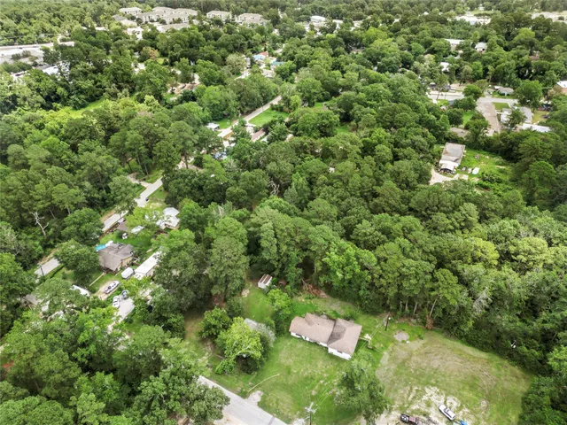 an aerial view of residential houses with outdoor space and trees
