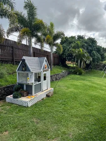 a view of a house with a big yard plants and large trees