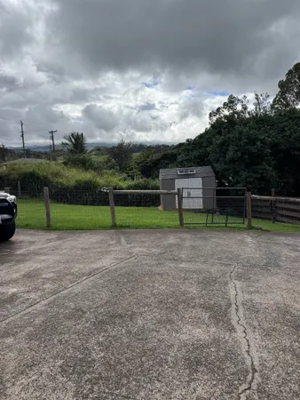 a view of a yard with wooden fence