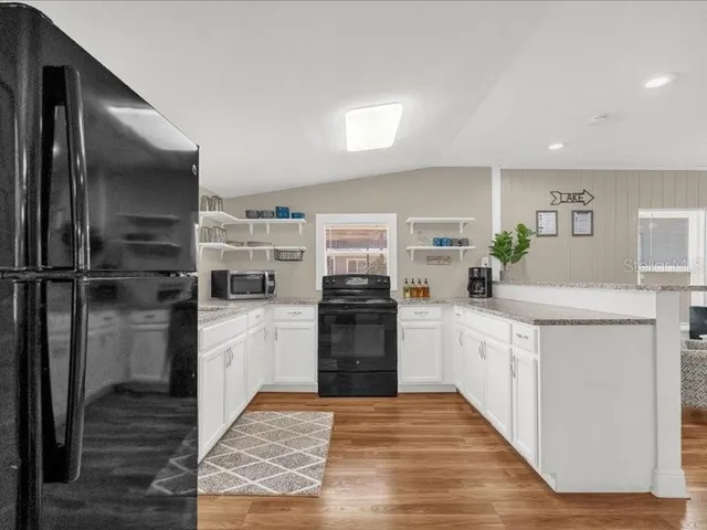 a kitchen with granite countertop a refrigerator and a sink