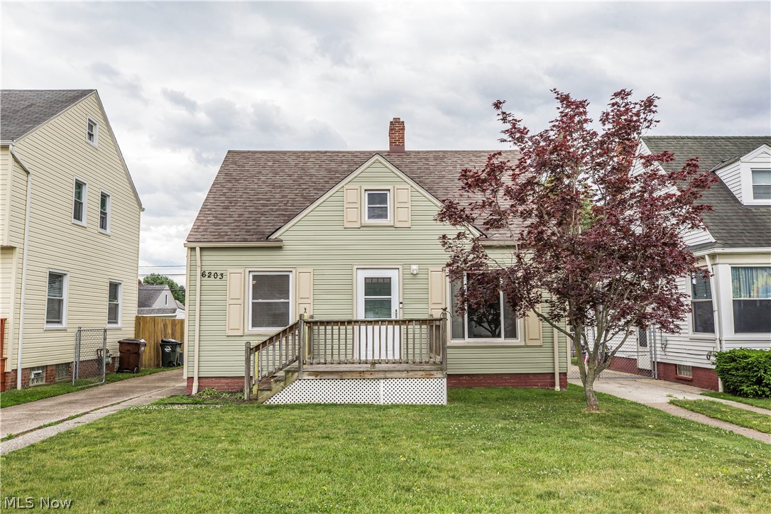 Cape cod house with a deck and a front lawn