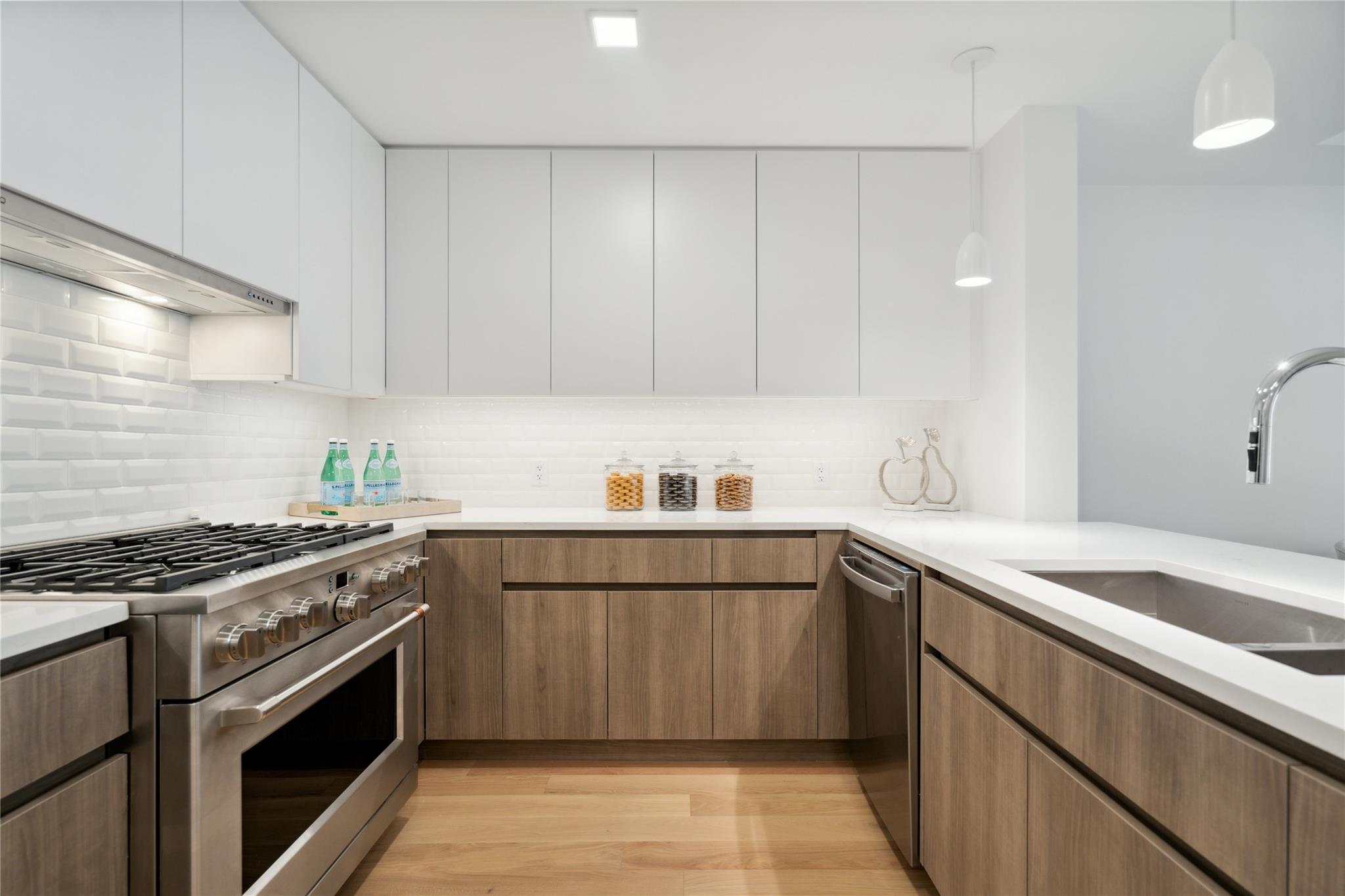218 Middle Neck Road, Unit 212 Great Neck, NY 11021 - Photo 1 of 1 Kitchen featuring appliances with stainless steel finishes, white cabinetry, light wood-type flooring, and light countertops