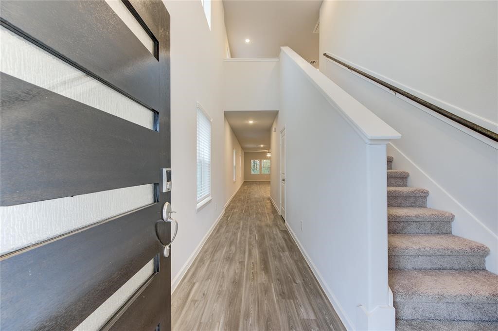 94 Valiant Ridge Trail Magnolia, TX 77354 - Photo 2 of 13 a view of a hallway with wooden floor and staircase