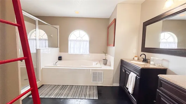 a bathroom with a bathtub sink and mirror