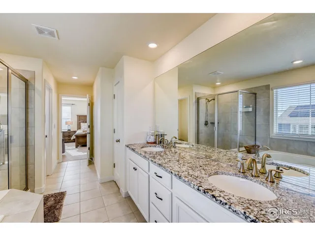 a bathroom with a granite countertop sink mirror and a bathtub