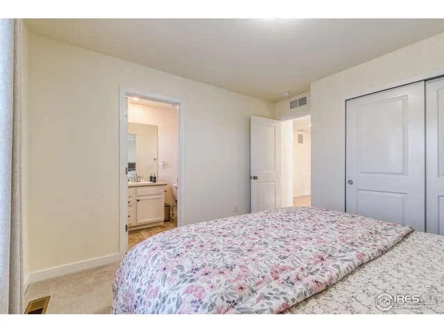 a bedroom with a bed and a view of kitchen