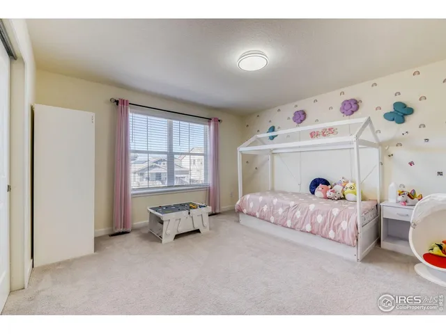 a living room with baby crib furniture and a window