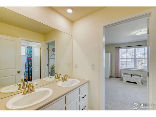 a en suite bathroom with a double vanity sink a mirror and a bathtub
