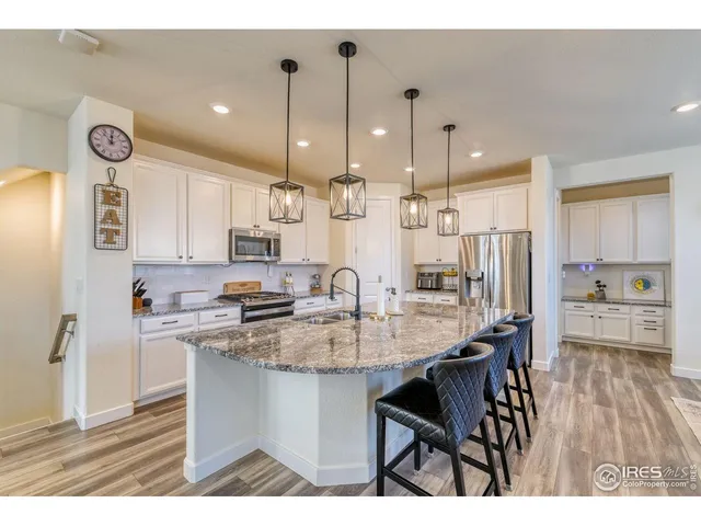 a kitchen with kitchen island granite countertop a sink cabinets and stainless steel appliances