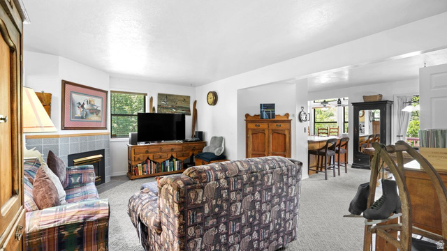 335 Jungfrau Hill Road Midway, UT 84049 - Photo 15 of 34 Living area featuring light colored carpet and a tiled fireplace