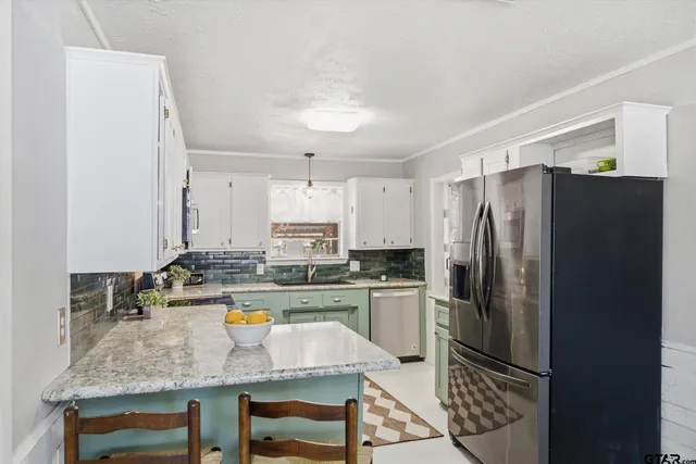 a kitchen with stainless steel appliances granite countertop a refrigerator a stove and a sink
