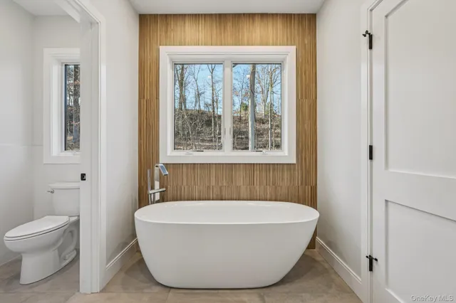 a bathroom with a white tub shower and toilet