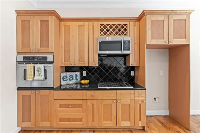 a kitchen with stainless steel appliances granite countertop a stove a sink and a microwave