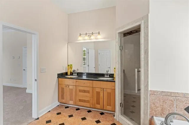 a en suite bathroom with a granite countertop sink and a mirror