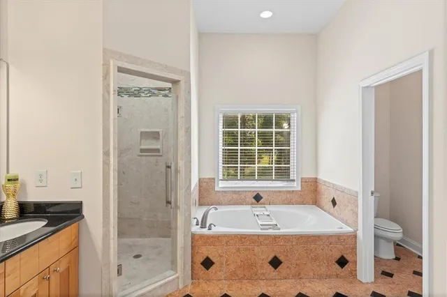 a bathroom with a granite countertop tub a sink and a window