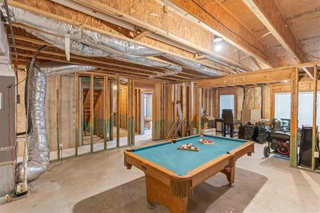 a room with pool table and large windows