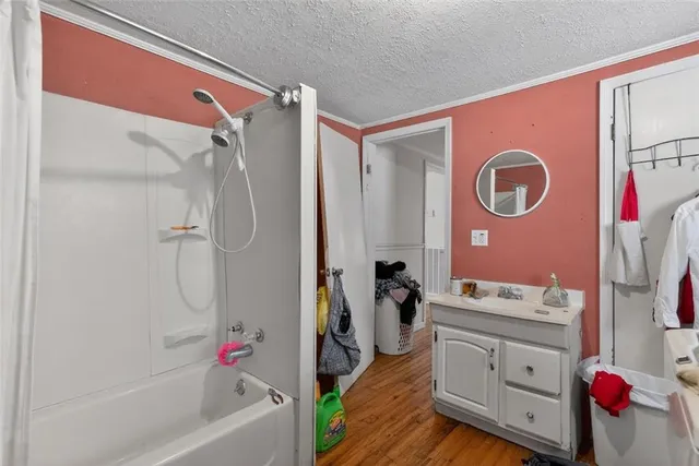 a bathroom with a bathtub shower sink and mirror