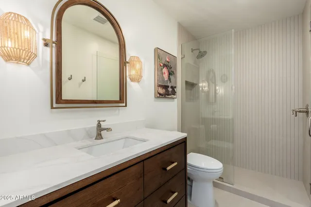 a bathroom with a sink a toilet and shower