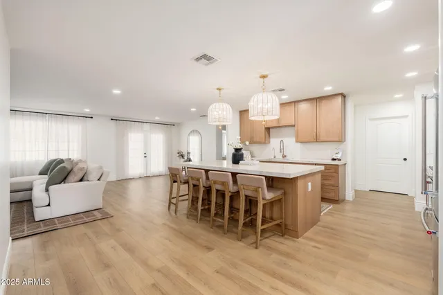 a large kitchen with kitchen island a sink table and chairs