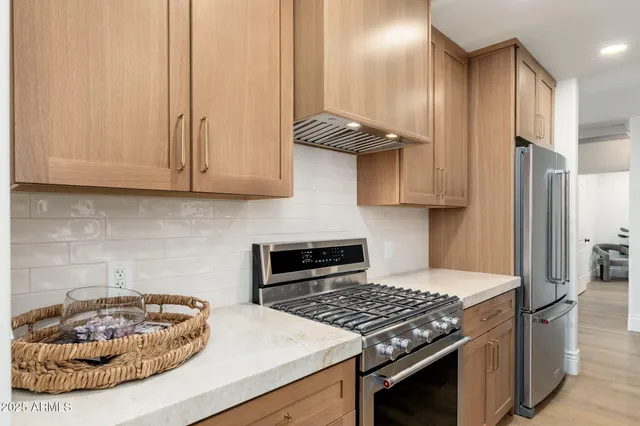 a kitchen with stainless steel appliances granite countertop a stove a refrigerator and a white cabinets