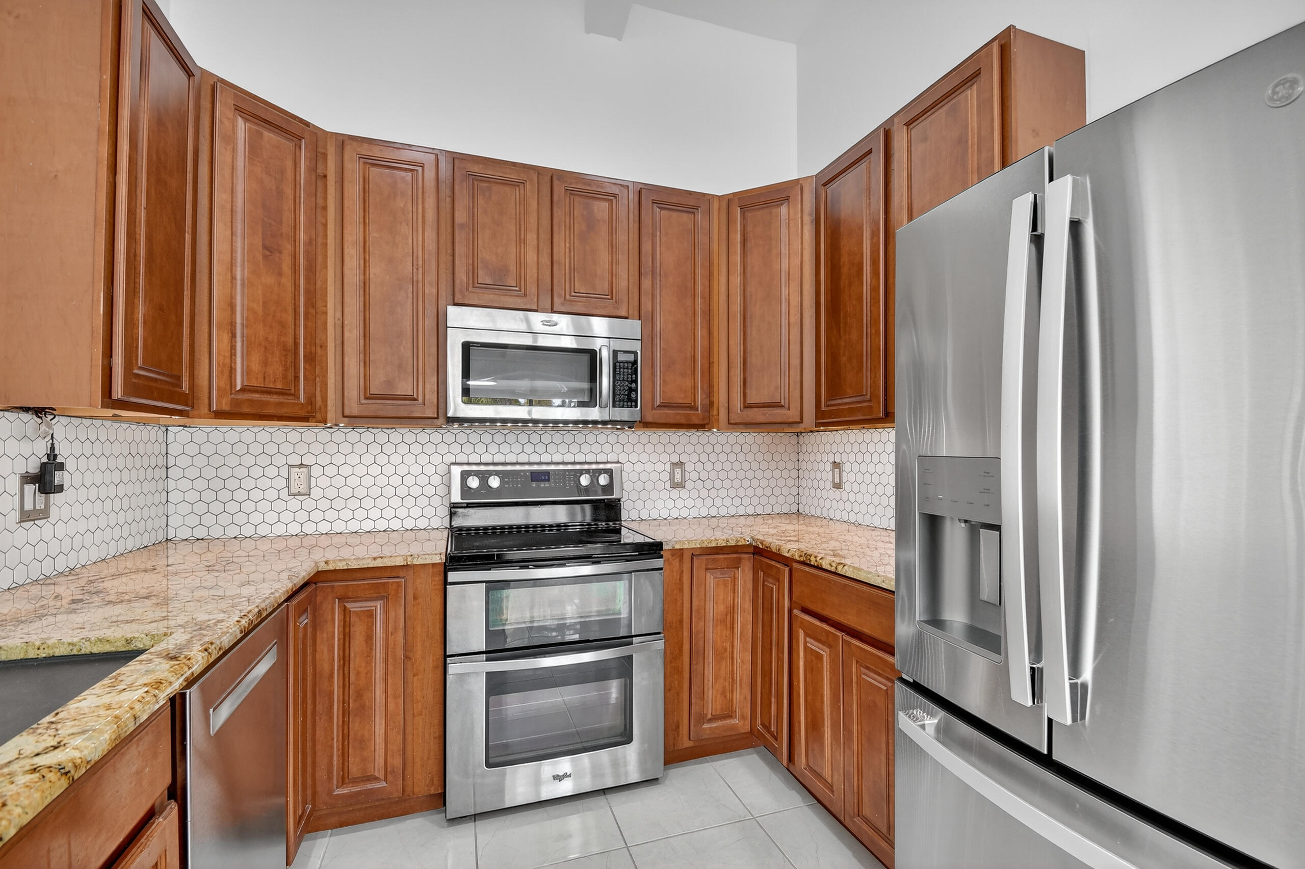 1877 Shower Tree Way Wellington, FL 33414 - Photo 12 of 53 a kitchen with stainless steel appliances granite countertop a refrigerator stove and sink