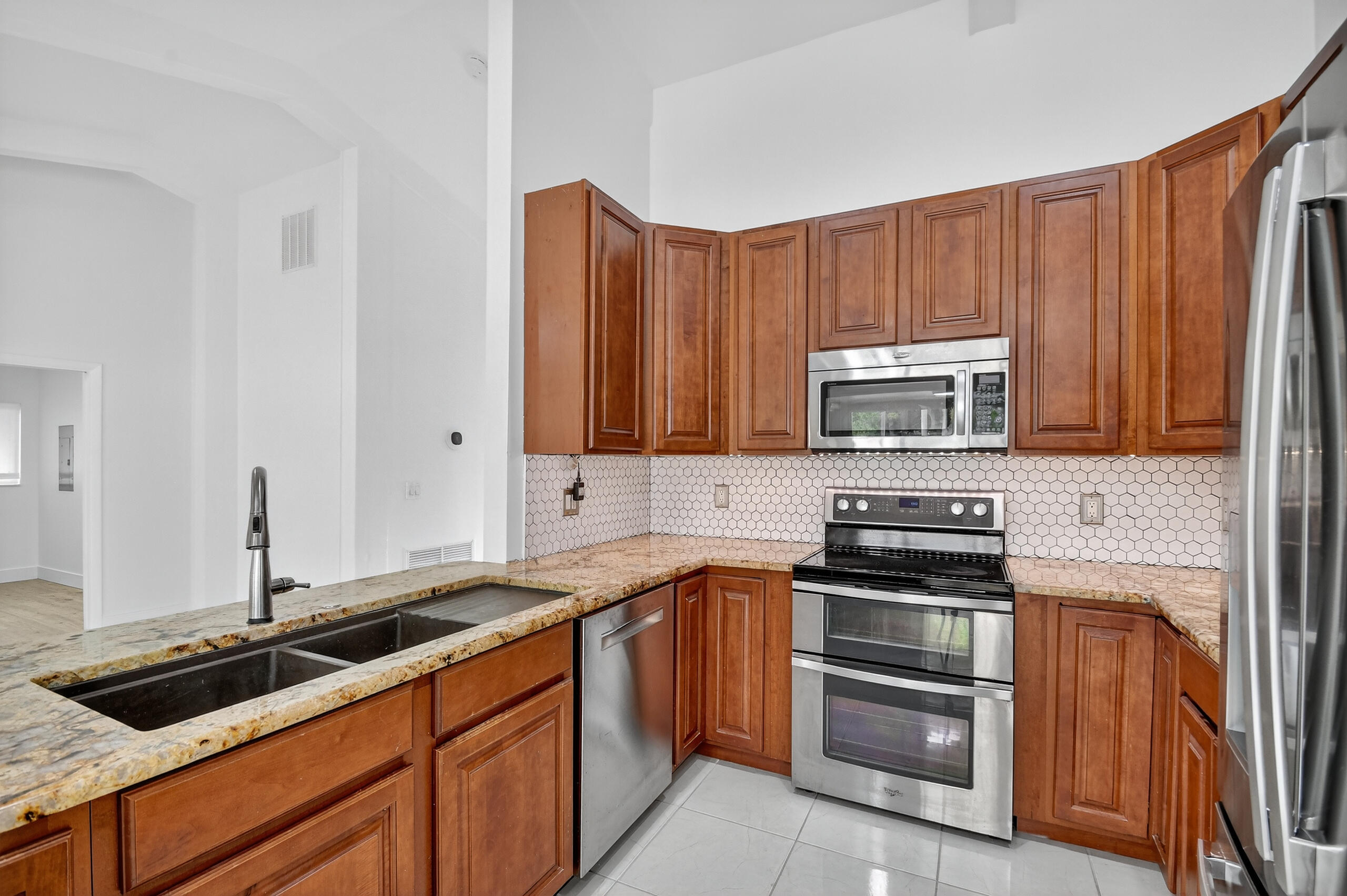 1877 Shower Tree Way Wellington, FL 33414 - Photo 14 of 53 a kitchen with stainless steel appliances granite countertop a sink and a stove