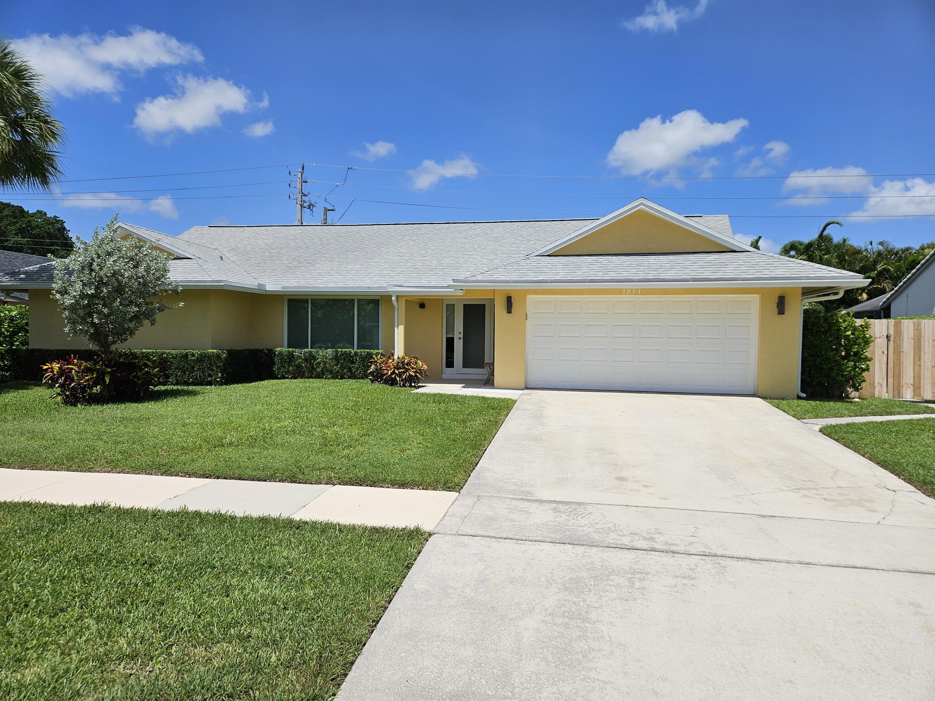 1877 Shower Tree Way Wellington, FL 33414 - Photo 2 of 53 a front view of a house with a yard