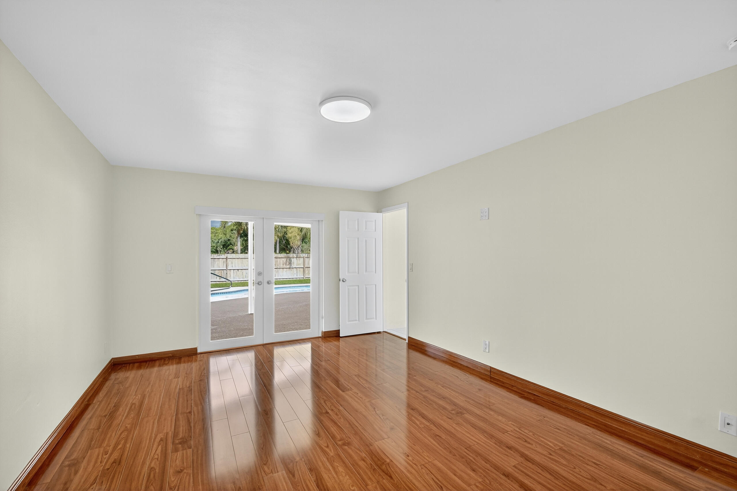 1877 Shower Tree Way Wellington, FL 33414 - Photo 26 of 53 an empty room with wooden floor and windows