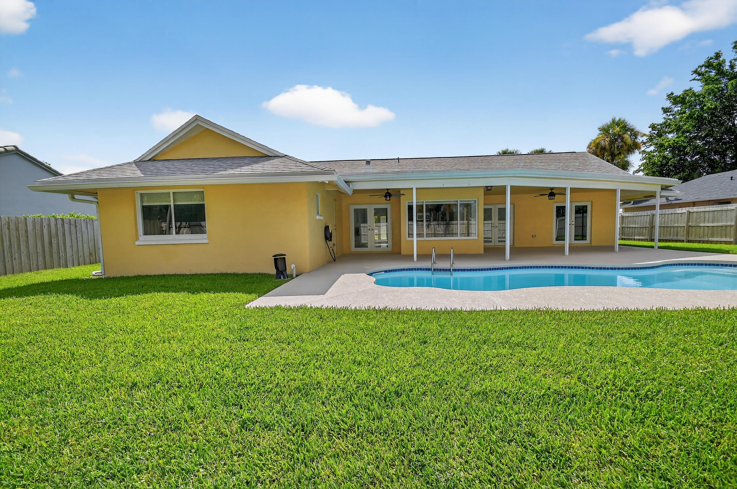 1877 Shower Tree Way Wellington, FL 33414 - Photo 52 of 53 a front view of a house with a yard and trees