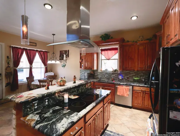 a kitchen with stainless steel appliances granite countertop a stove a sink and a refrigerator