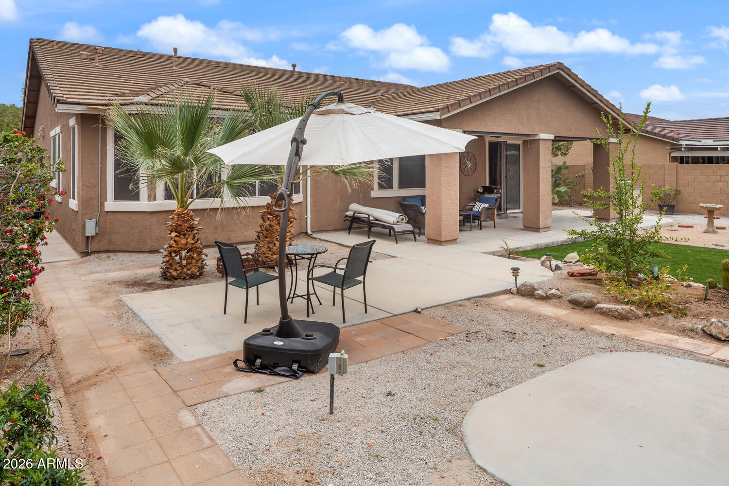 3246 North Springfield Street Buckeye, AZ 85396 - Photo 22 of 27 a patio with a table and chairs under an umbrella