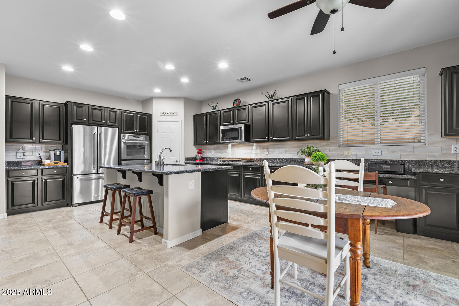 3246 North Springfield Street Buckeye, AZ 85396 - Photo 6 of 27 a kitchen with kitchen island a refrigerator stove microwave and cabinets