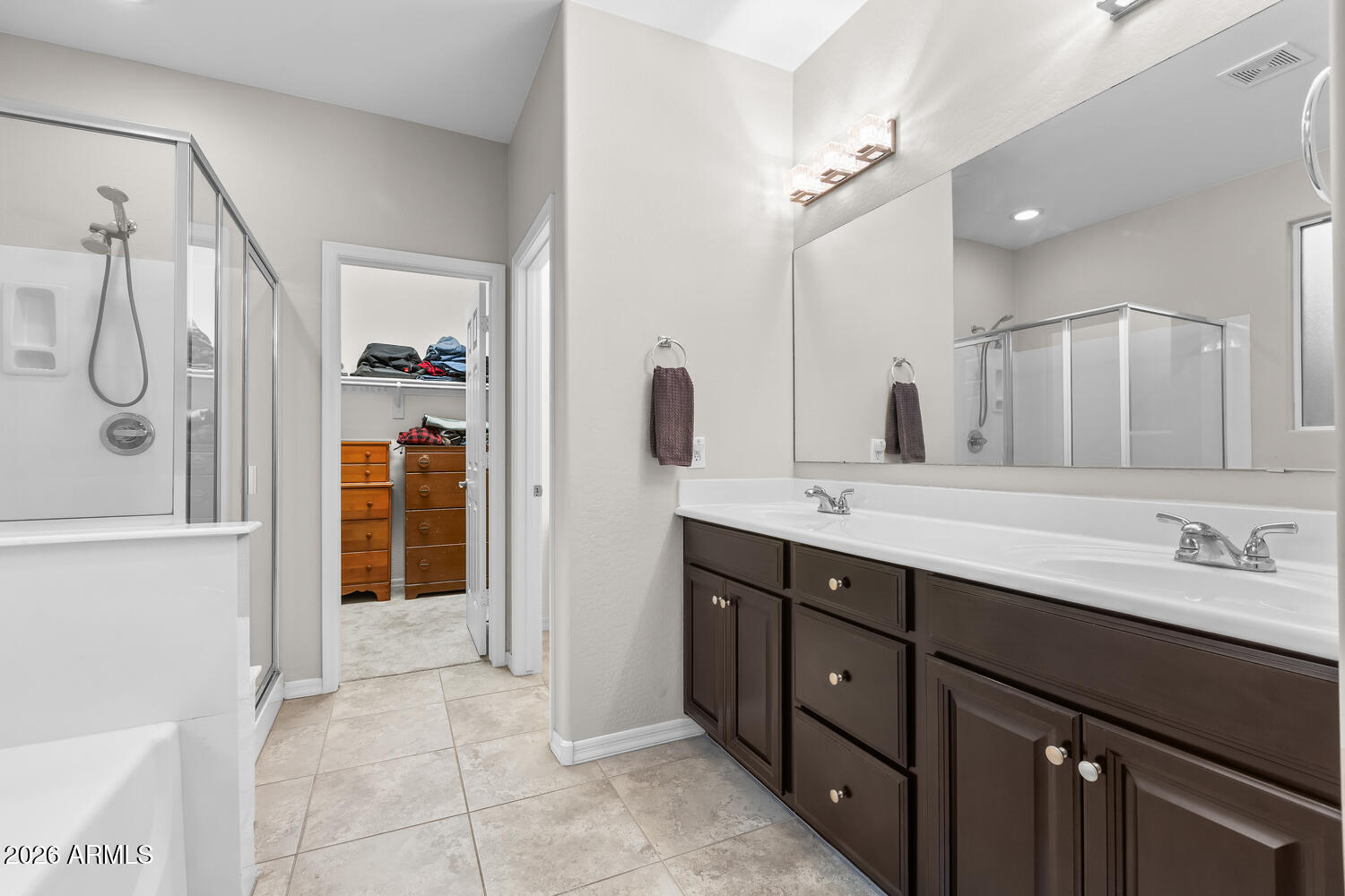 3246 North Springfield Street Buckeye, AZ 85396 - Photo 10 of 27 a spacious bathroom with a double vanity sink a large mirror and shower