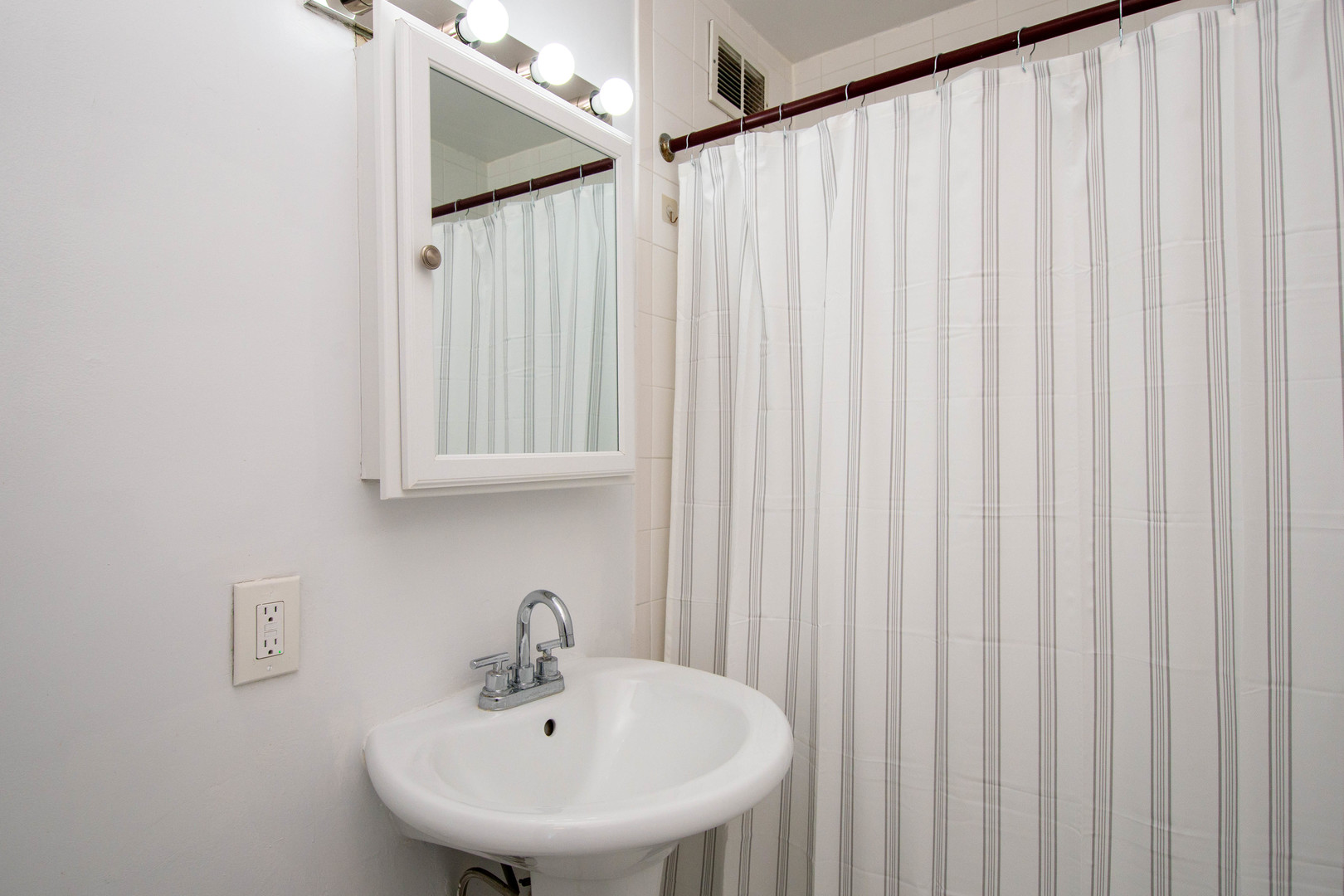 1401 East 55th Street, Unit 701N Chicago, IL 60615 - Photo 5 of 10 a bathroom with a sink and a mirror