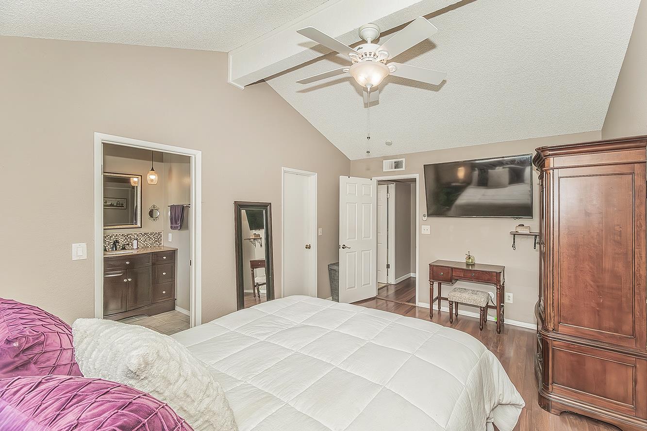 1908 East Niles Avenue Fresno, CA 93720 - Photo 15 of 30 a bedroom with a bed and a chandelier