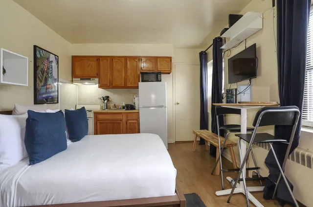 a kitchen with a table chairs refrigerator and microwave