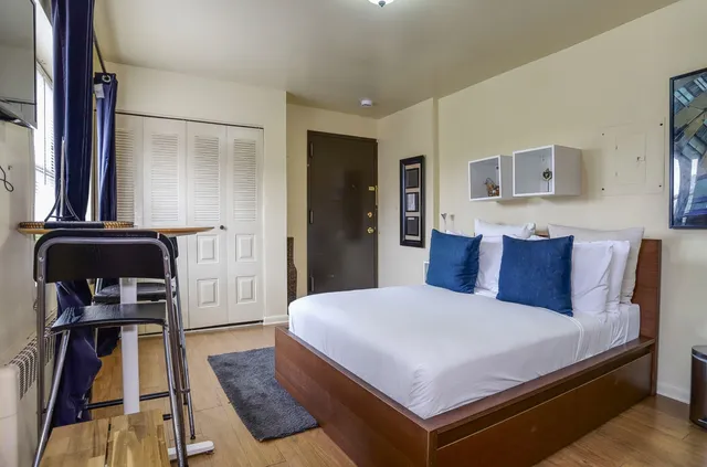 a bedroom with a bed and wooden floor