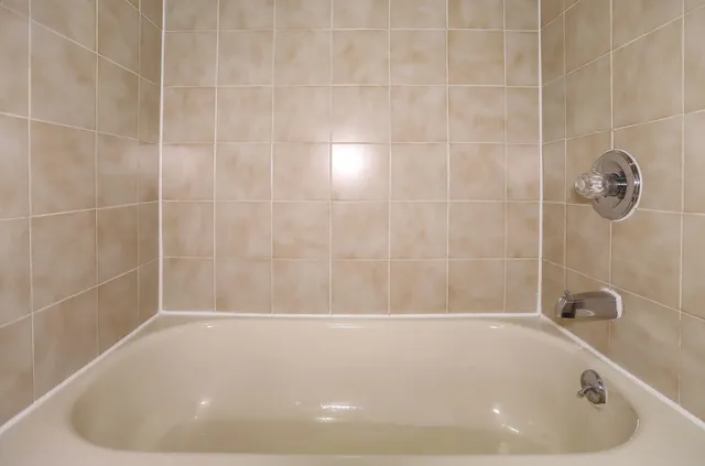 a white bath tub sitting in a bathroom and shower