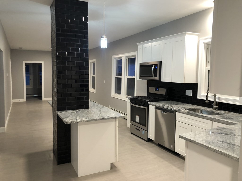 135 Winthrop Street Fall River, MA 02721 - Photo 11 of 26 a kitchen with stainless steel appliances granite countertop a sink and a stove